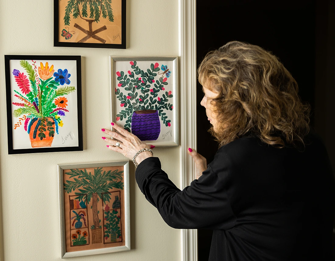 Resident admiring artwork in a hallway of the facility