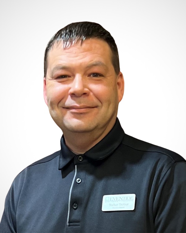 Staff member smiling in a uniform with name tag