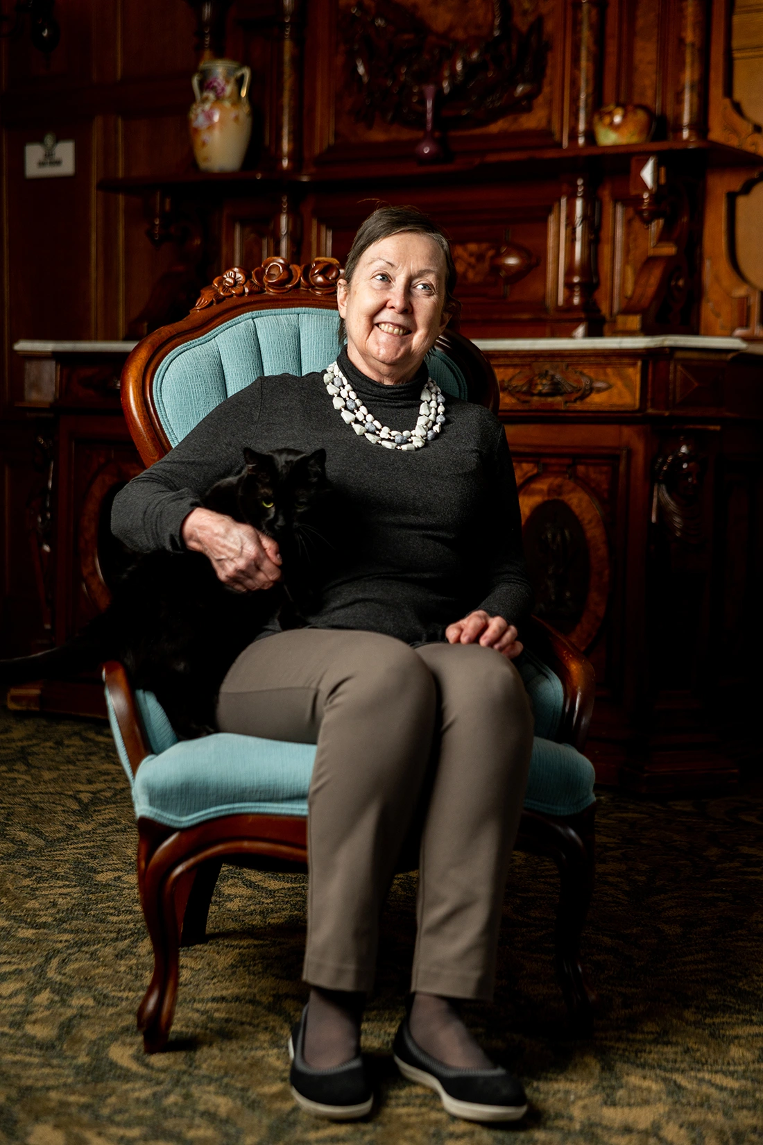 Senior resident sitting in a chair holding a cat