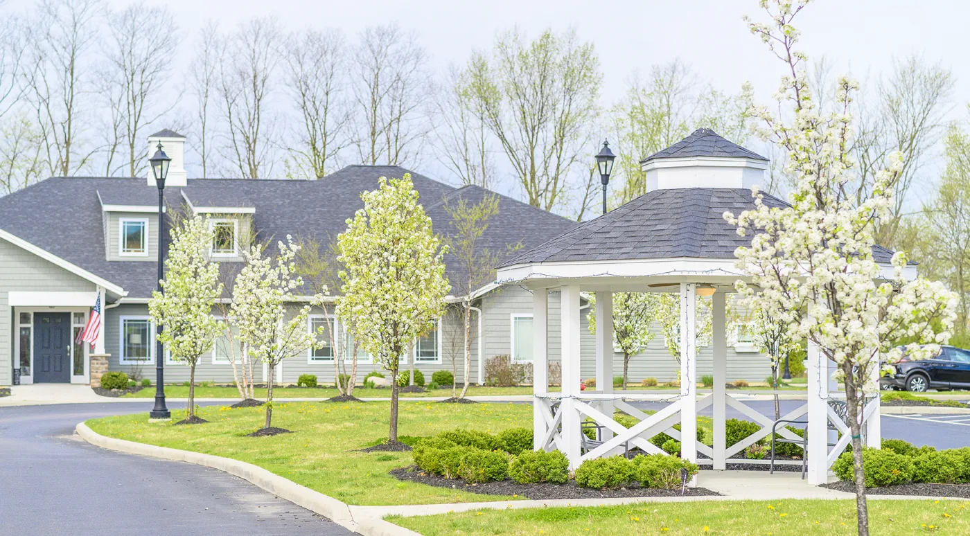 Exterior view of the facility with blooming trees and gazebo