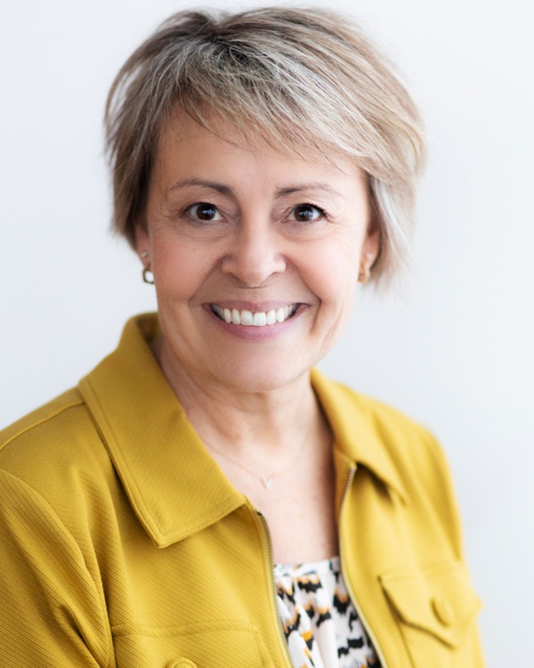 A smiling woman in a yellow jacket