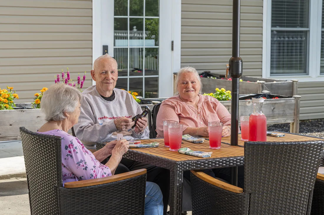 Residents enjoying refreshments on a sunny patio