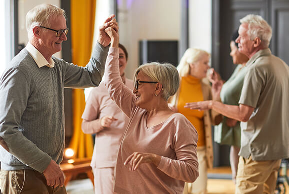 Residents dancing in a lively common area