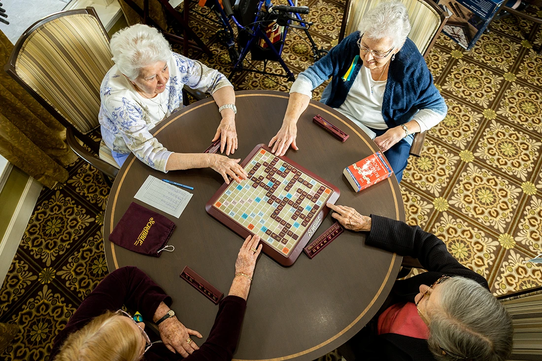 Residents playing Scrabble around a table