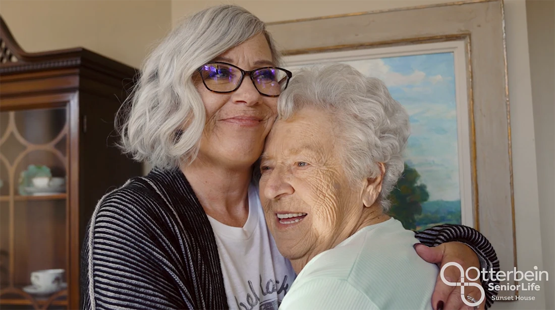 Two women embracing in a warm indoor setting