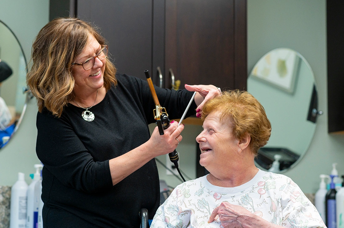 Resident getting a haircut from a stylist