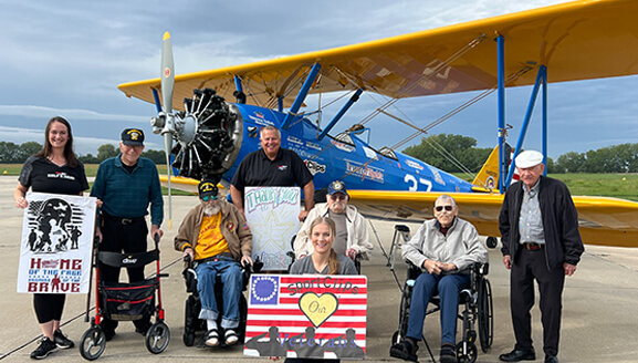 Residents and staff celebrating an outing with a biplane