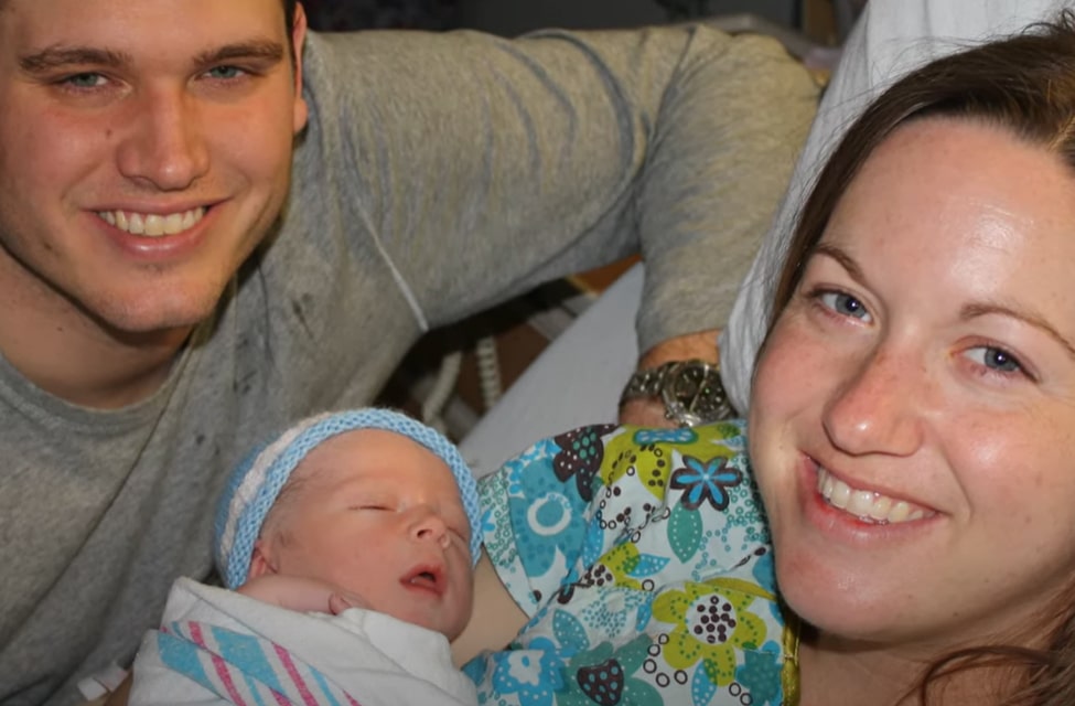 New parents smiling with their newborn baby