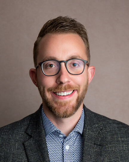 Smiling man wearing glasses and a blazer