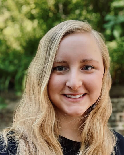 Close-up of a smiling staff member outdoors