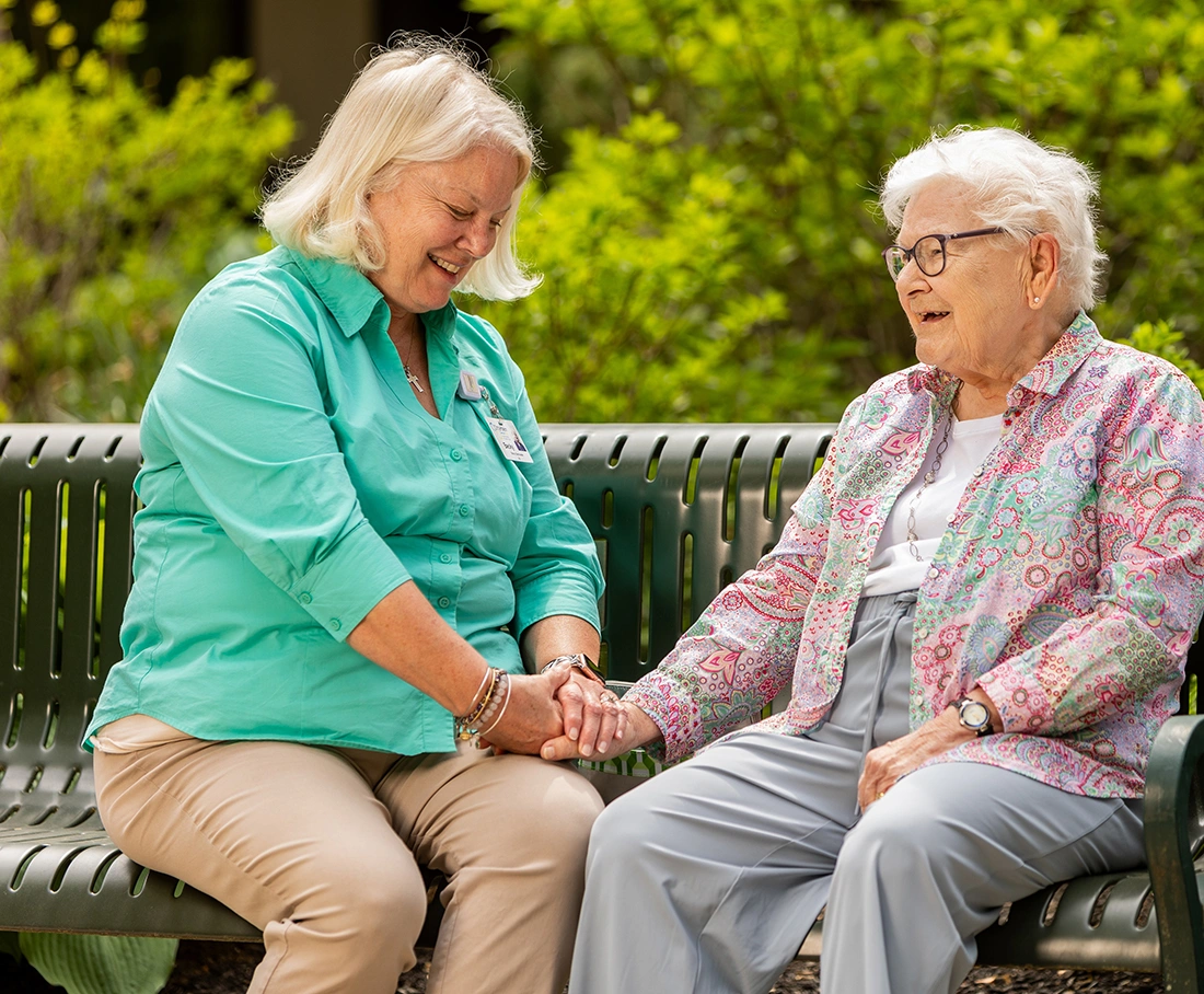 A staff member and resident enjoying a conversation outdoors
