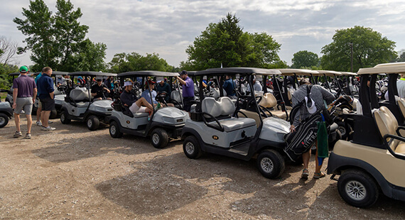 Golf carts lined up at an outdoor event