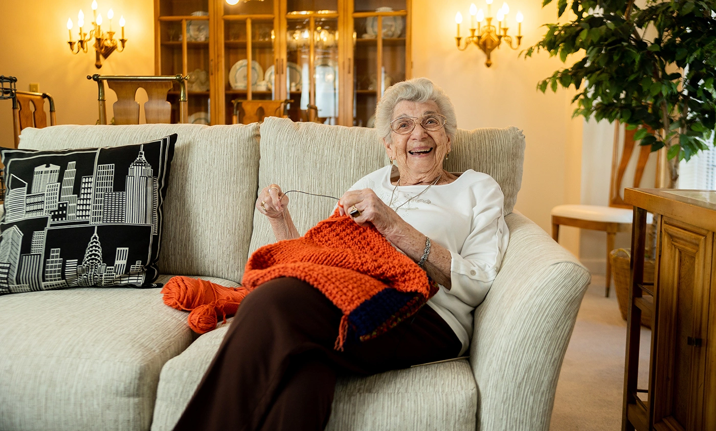 Resident knitting in a cozy living room