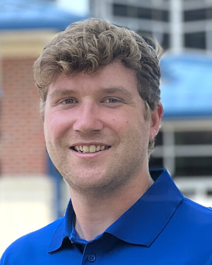 Smiling staff member in a blue polo