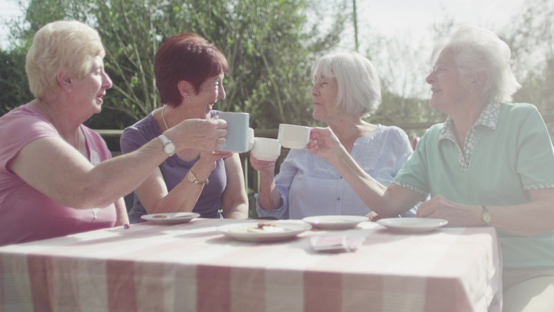 Residents enjoying tea outside on a sunny day