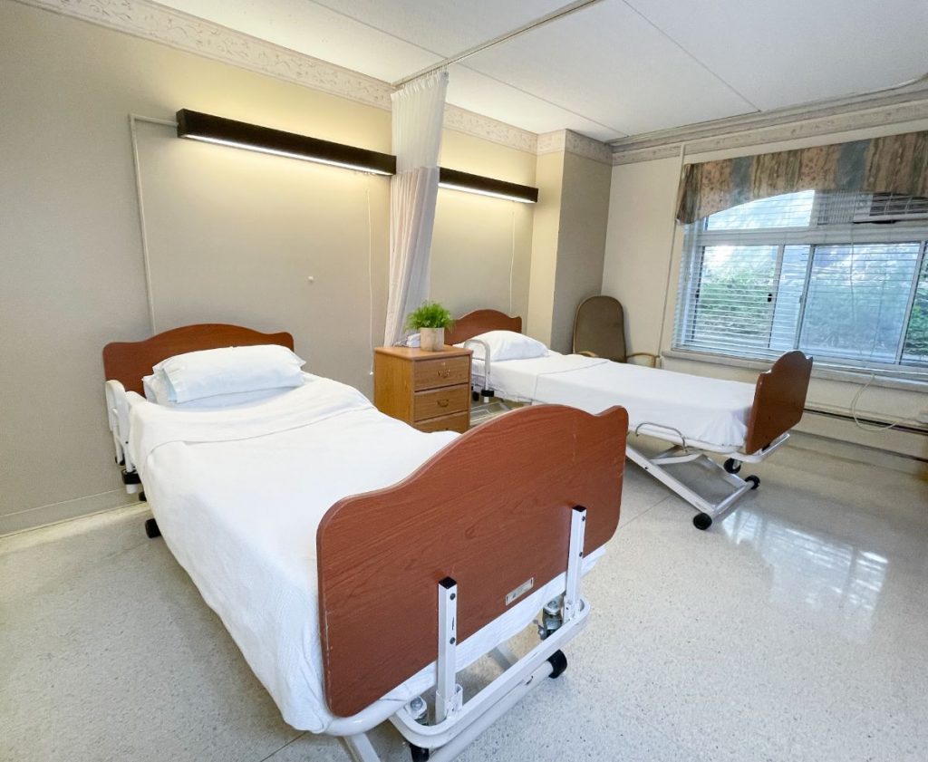 A shared resident room with two beds and natural light