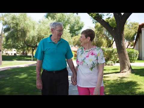 Couple walking hand in hand in a sunny outdoor area