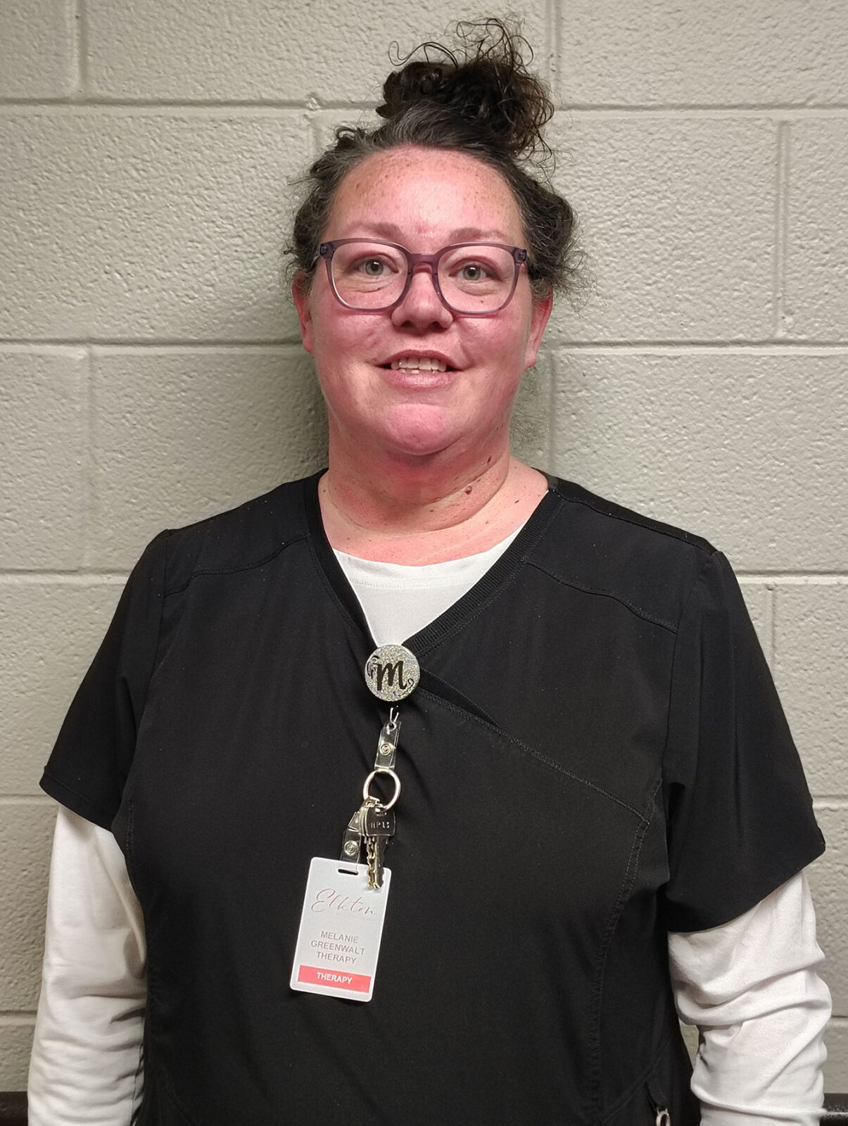 Staff member in scrubs with name badge