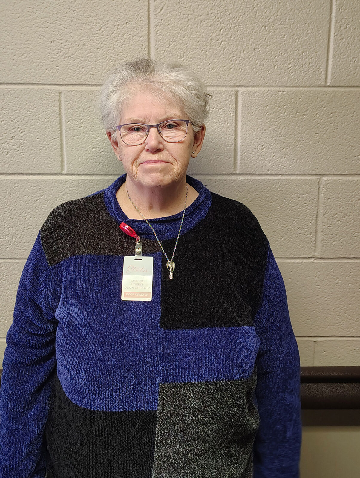 Senior resident in a cozy setting with a name tag