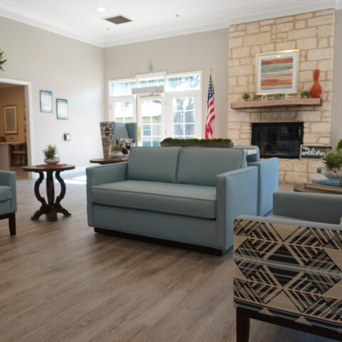 Bright and inviting common area with couches and fireplace.