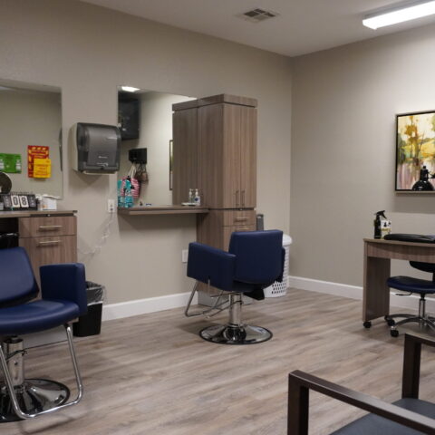 Hair salon setup with styling chairs and mirrors.
