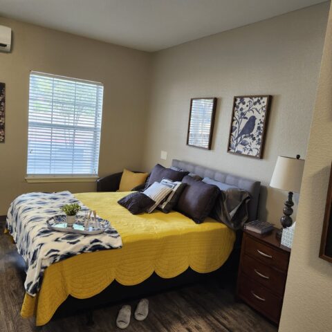 Brightly decorated resident bedroom with yellow accents.