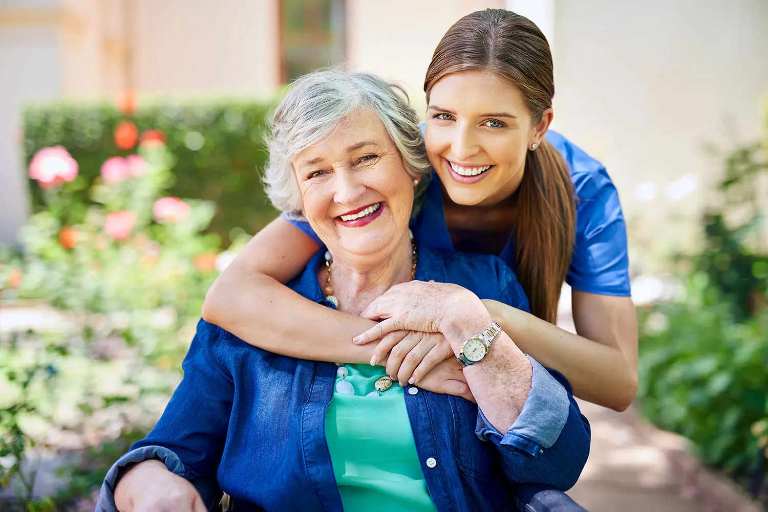 Happy resident and staff member in a garden