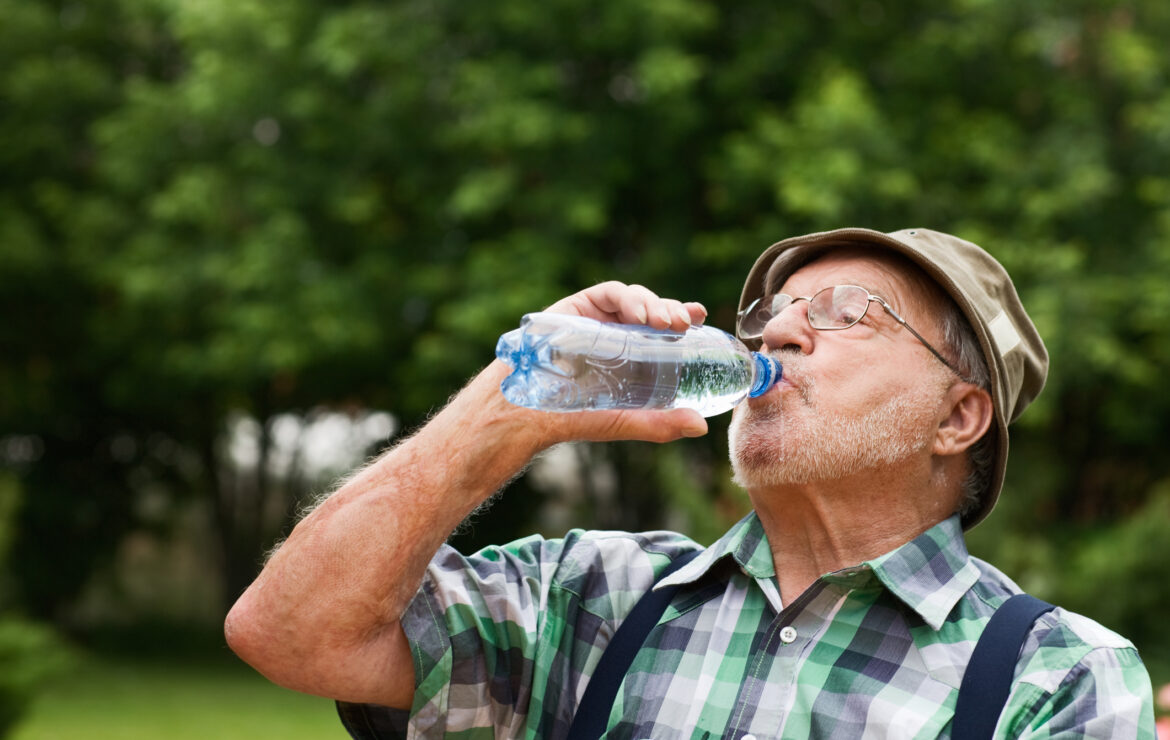 Senior man drinking water outdoors