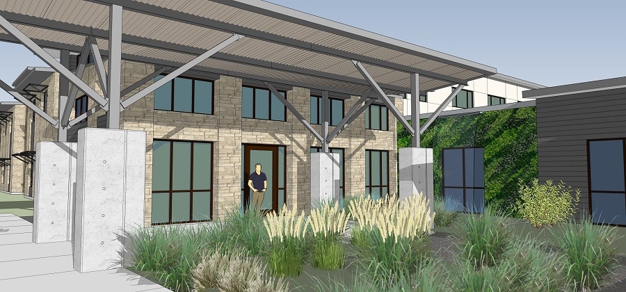 Front entrance of assisted living facility with person and landscaping.