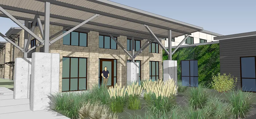 Building entrance with landscaping and a person standing