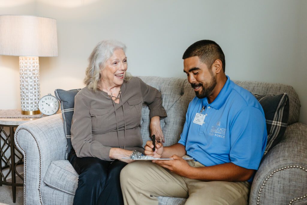 Staff member engaging with a resident in a cozy lounge.