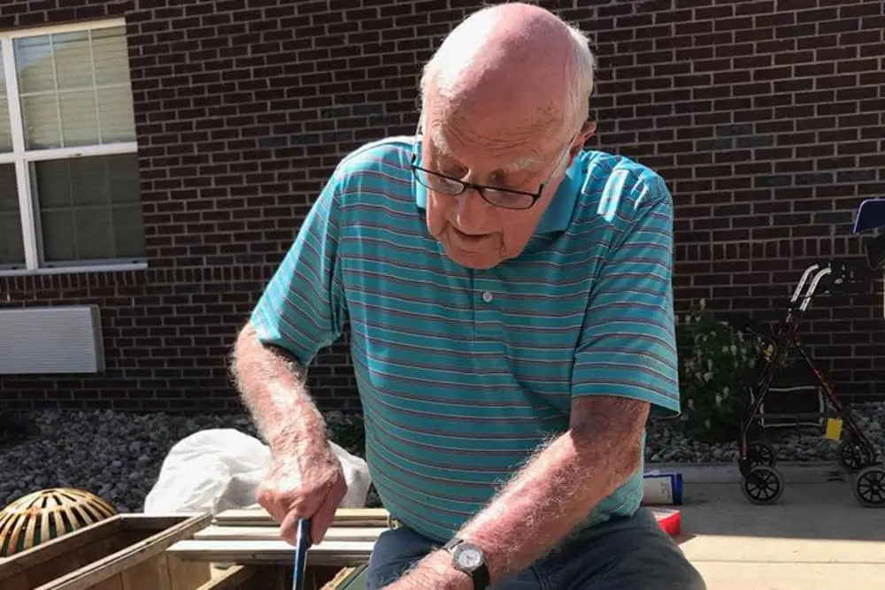 Senior man gardening outdoors at the facility