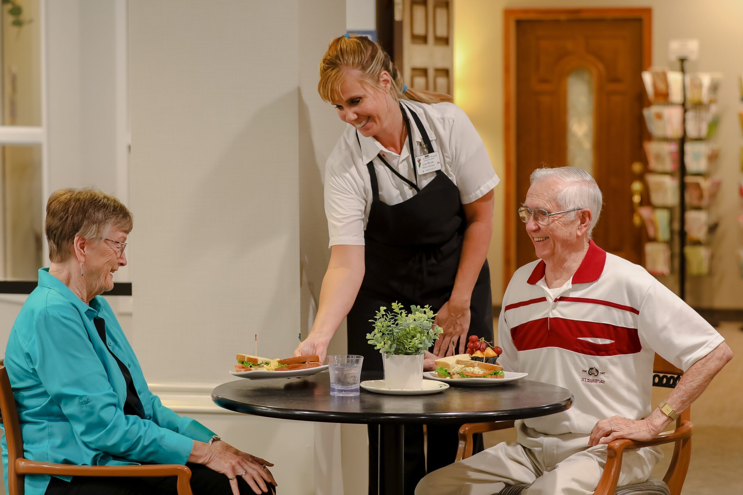 Residents enjoying a meal served by staff.