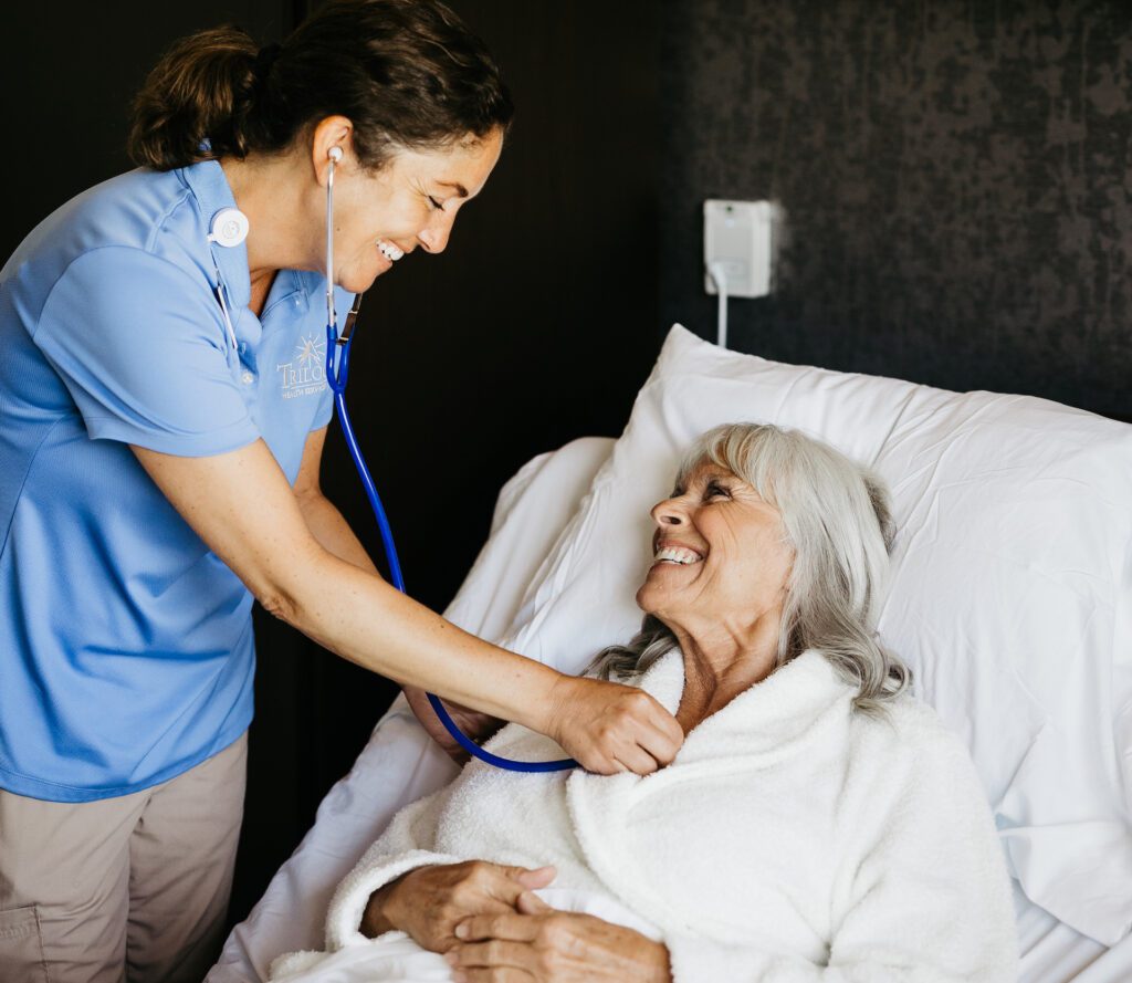 Staff member caring for resident in bed