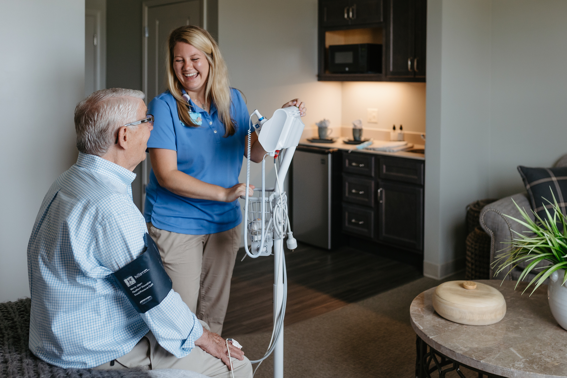 Caregiver assisting a resident with medical equipment.