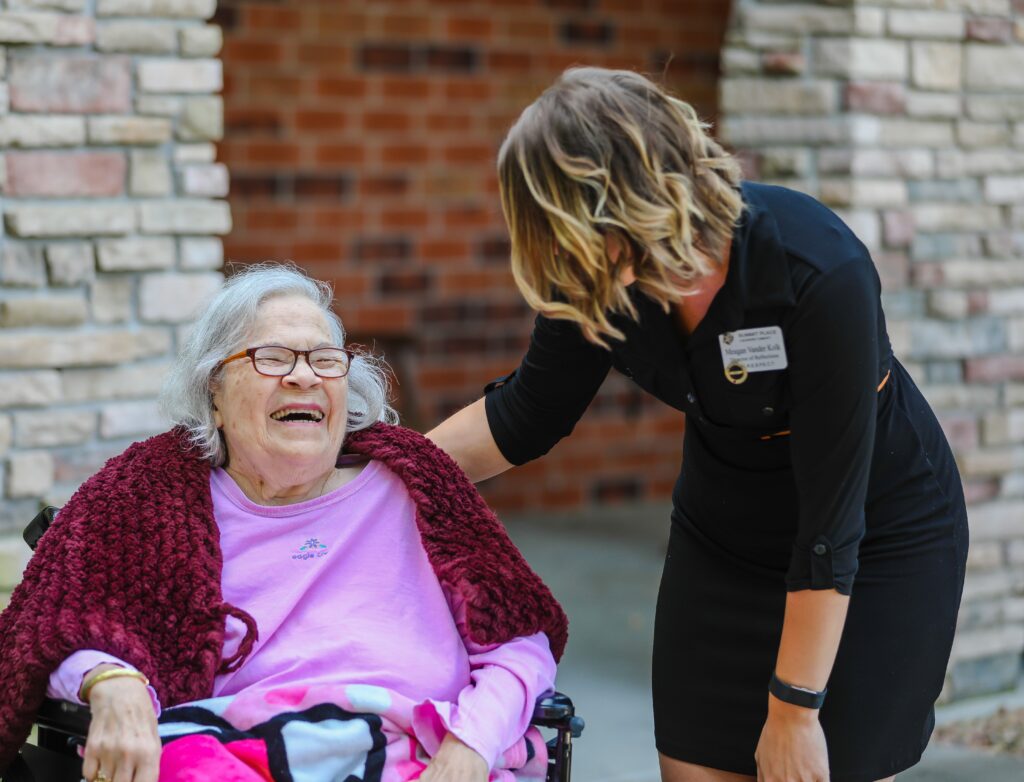 Resident smiling with staff member outdoors