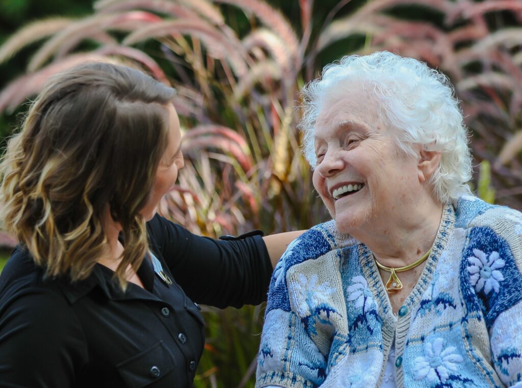 Caregiver and resident enjoying time outdoors.