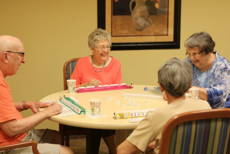 Residents enjoying a game at a round table