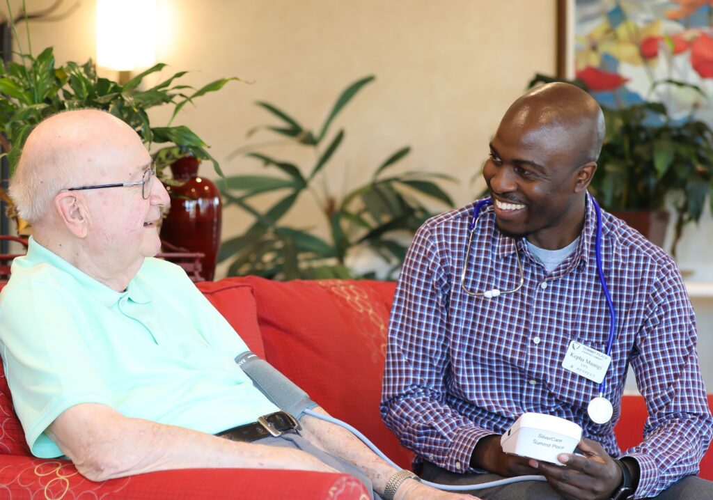 Resident chatting with staff in a common area.