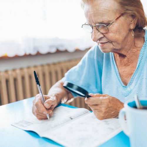 Senior woman studying with a magnifying glass