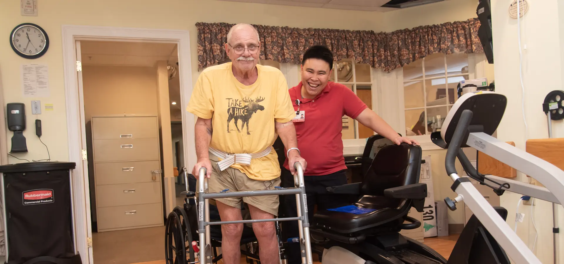 Staff assisting resident with rehabilitation equipment.