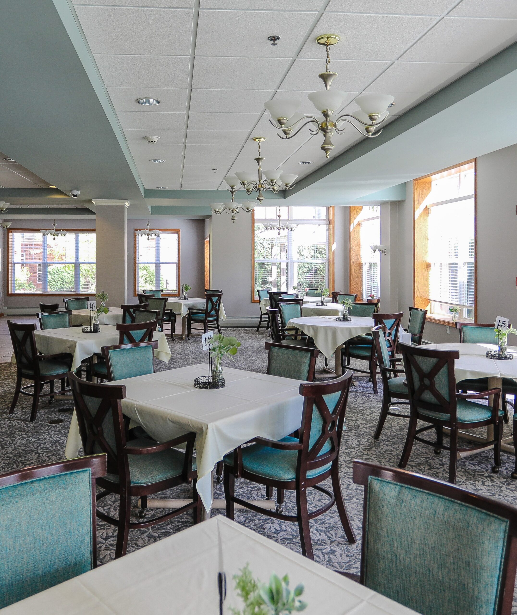 Well-lit dining room with tables and chairs