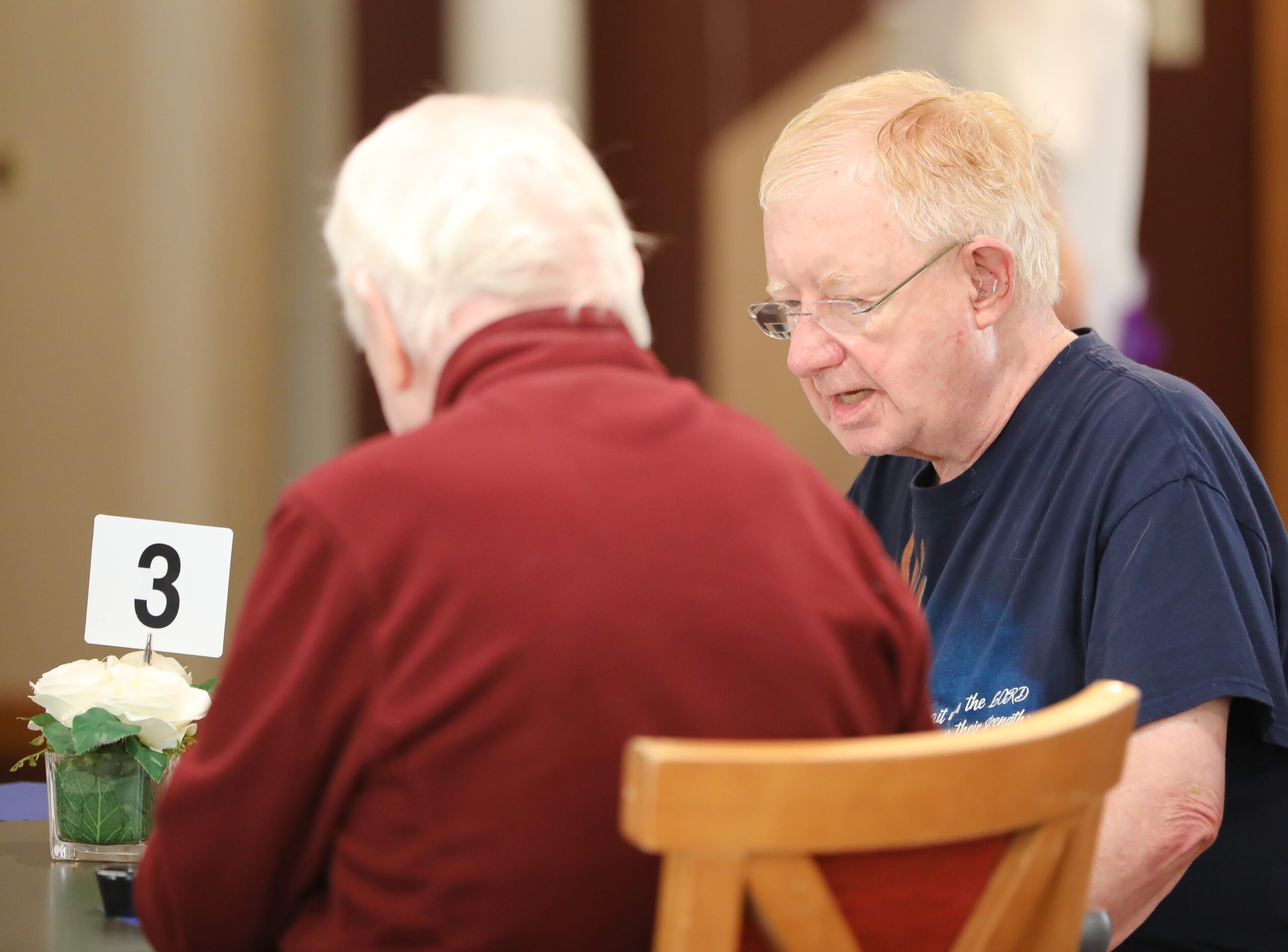 Two men engaged in conversation at a table.