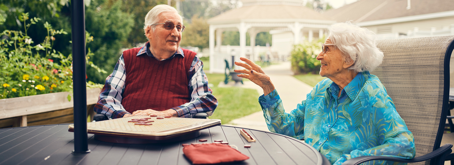 Two seniors engaged in conversation outdoors.