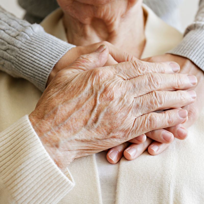Close-up of elderly hands and gentle touch.