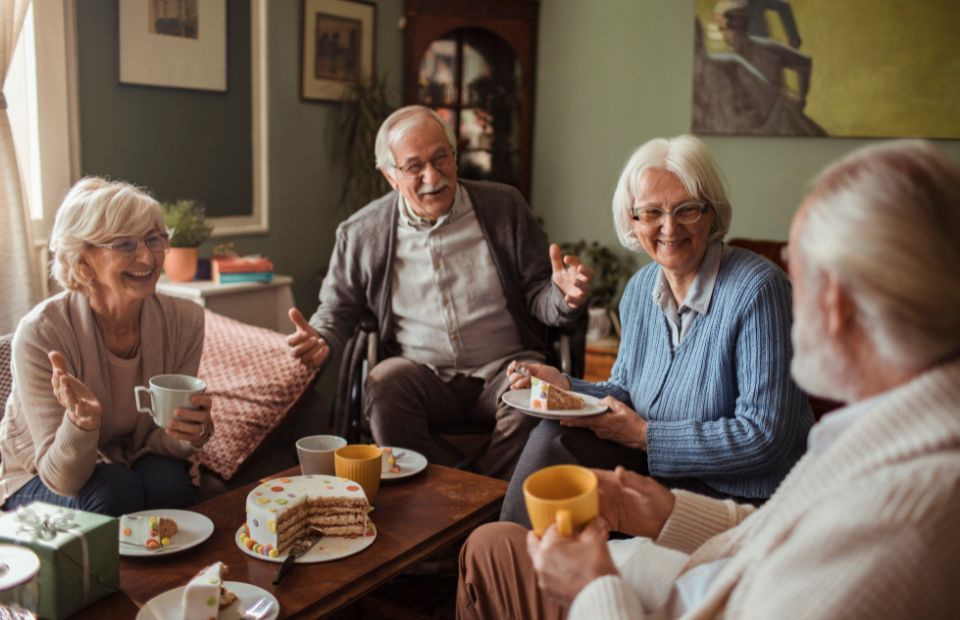 Seniors enjoying cake and conversation in a cozy setting.