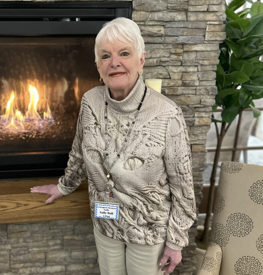 Resident posing by a fireplace in a common area