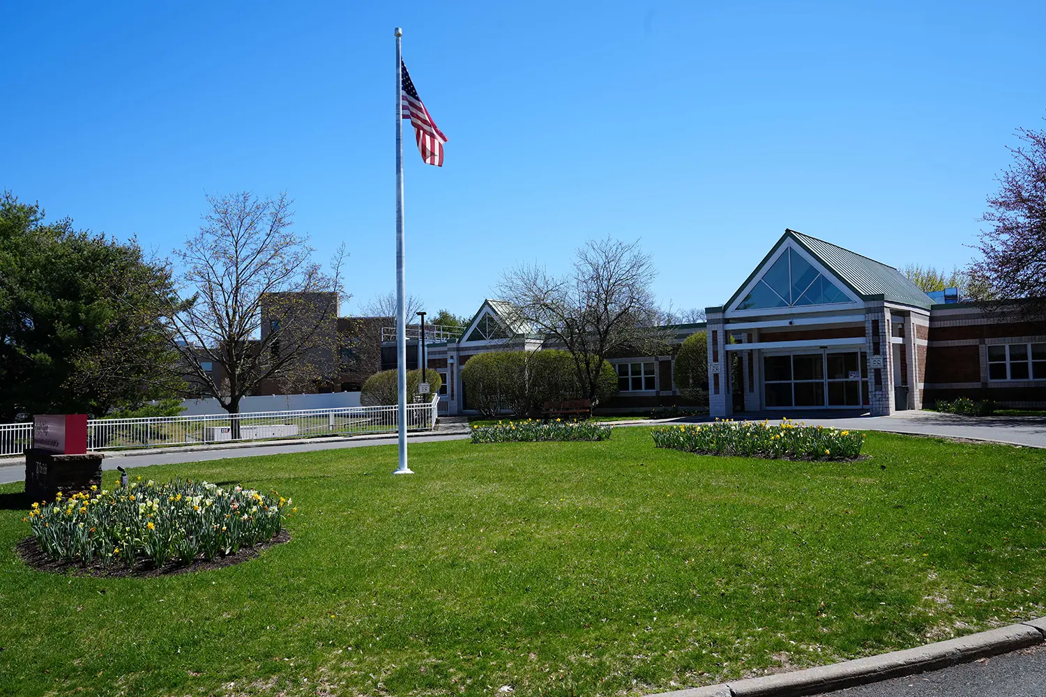 Exterior view of the nursing home with garden and flag