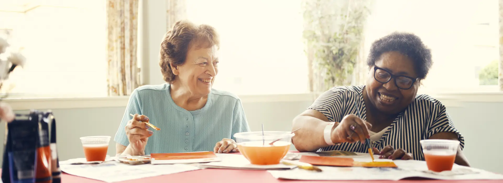 Two residents painting and enjoying an activity together.