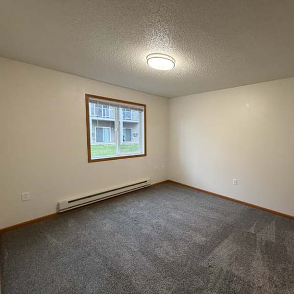 Empty, well-lit resident room with window